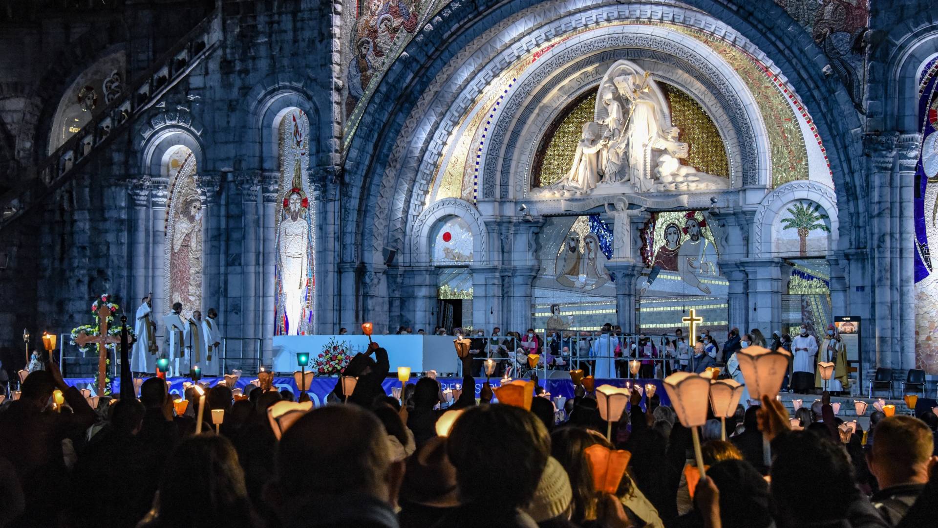 Procession aux flambeaux devant la basilique Notre-Dame-du-Rosaire à Lourdes de nuit